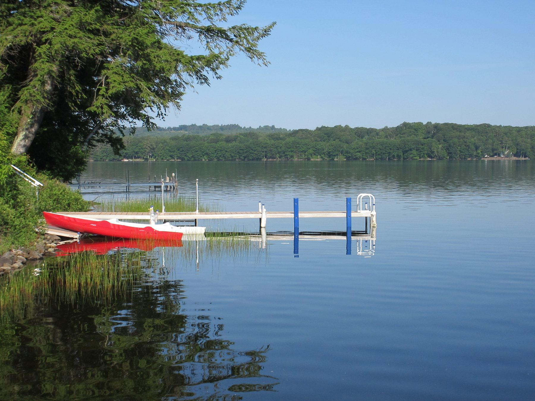 Red and white kayaks tied at a small dock