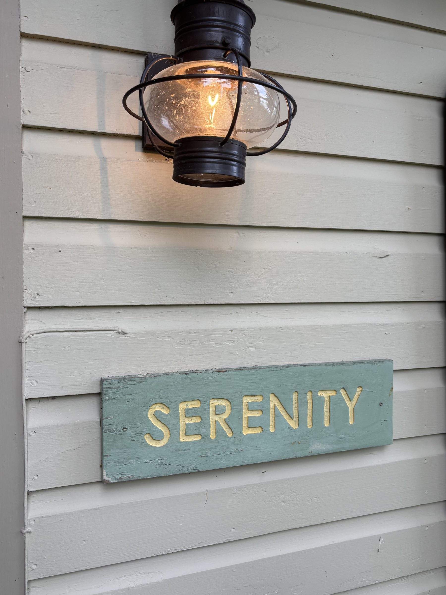 Serenity cabin nameplate sign with lantern light